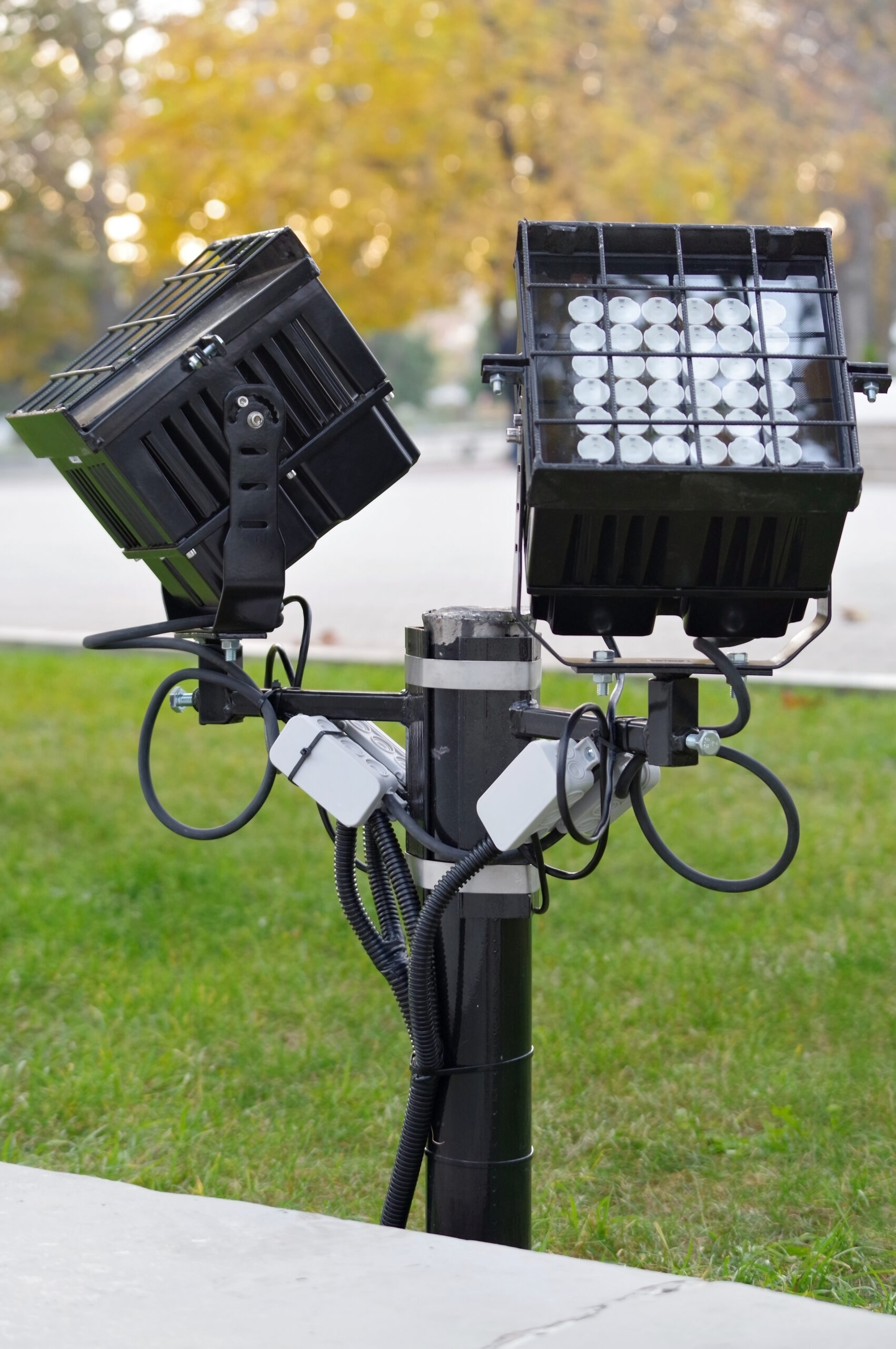 Two black LED floodlight fixtures mounted on posts, the kind used for security landscape lighting in the San Fernando Valley