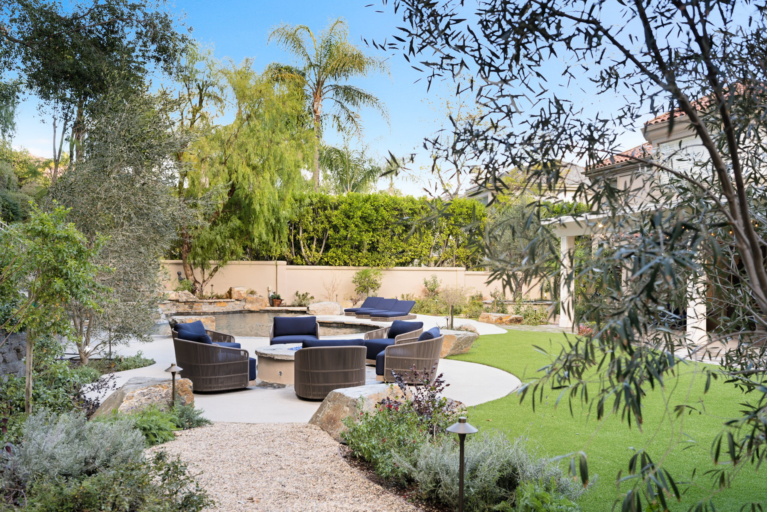 Luxury home backyard landscaping with a pool, pergola, hedges, and mature trees in the San Fernando Valley