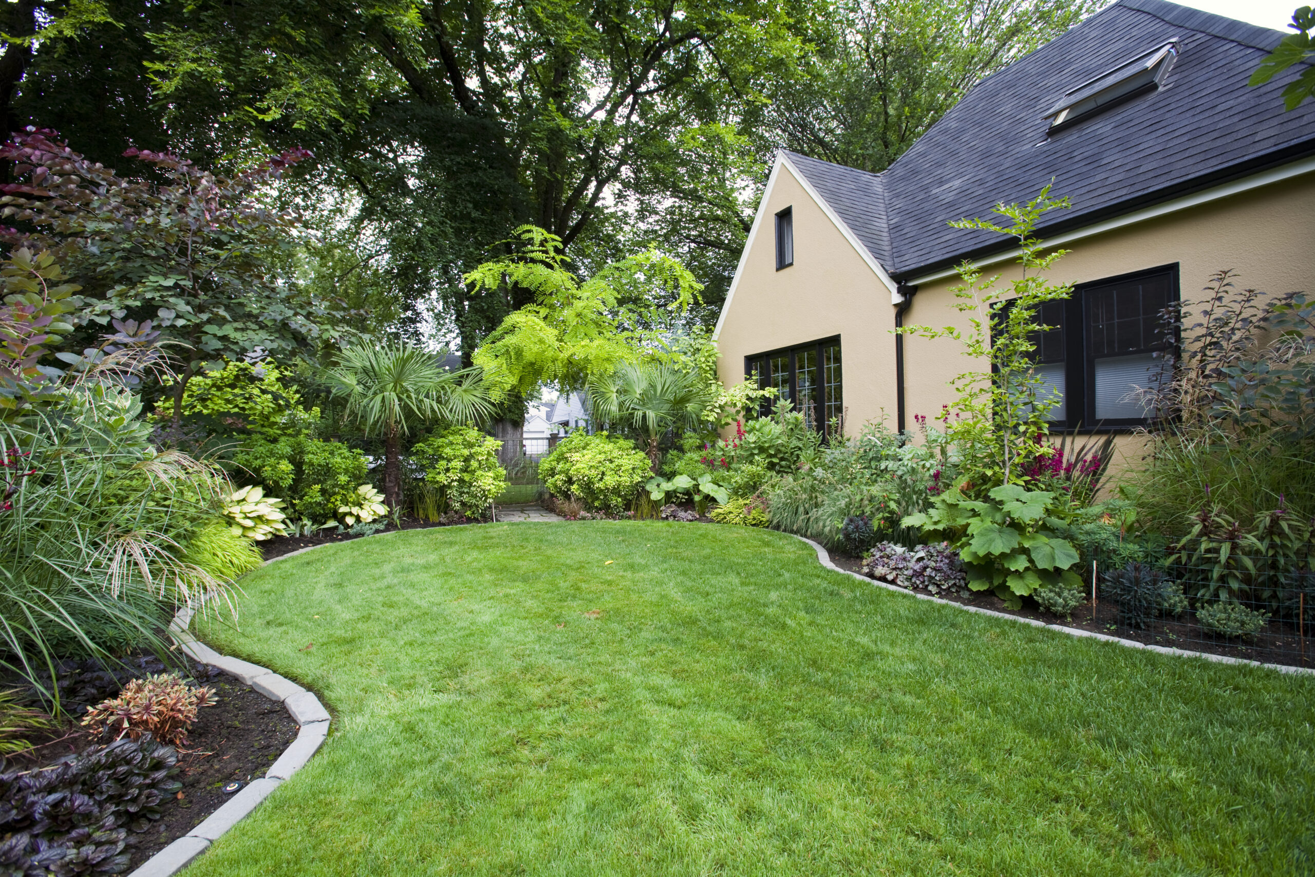 Lush garden with green lawn around a home showing landscape lighting benefits in the San Fernando Valley.